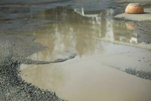 groß Pfütze im Straße. Pfütze und Dreck. Wasser im Frühling. foto