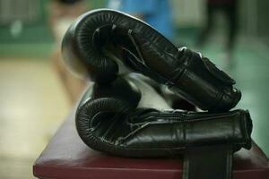 Boxen Handschuhe. schwarz Handschuhe im trainieren Zimmer. Sport Ausrüstung. foto