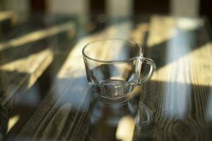 leeren Tasse auf Tisch. transparent Glas Tasse. Geschirr auf Tisch. foto