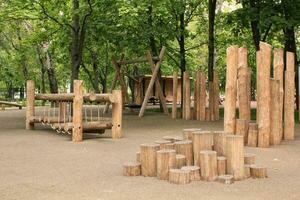 hölzern Spielplatz gemacht von natürlich umweltfreundlich Material im Öffentlichkeit Stadt Park. modern Sicherheit Kinder draussen Ausrüstung. Konzept von nachhaltig Lebensstil und Ökologie. Kinder sich ausruhen und Spiele auf öffnen Luft foto