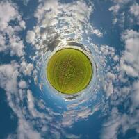 grüner winziger Planet im blauen Himmel mit schönen Wolken mit Transformation des sphärischen Panoramas 360 Grad. Krümmung des Raumes. foto