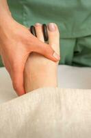 Massagegerät tun Füße und Zehen Massage mit Felsen zwischen ein weiblich Zehen. foto