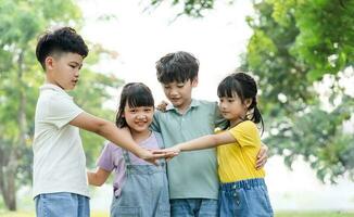 Gruppe von süß asiatisch Kinder haben Spaß im das Park foto