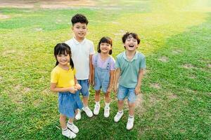 Gruppe von süß asiatisch Kinder haben Spaß im das Park foto