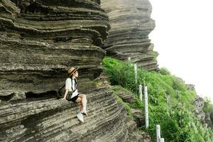 Bild von ein Mädchen Sitzung auf ein majestätisch Cliff foto