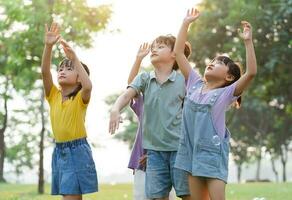 Gruppe Bild von süß asiatisch Kinder spielen im das Park foto