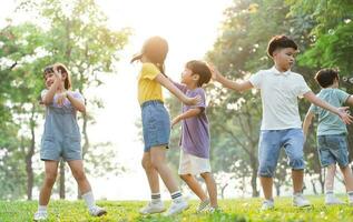 Gruppe Bild von süß asiatisch Kinder spielen im das Park foto