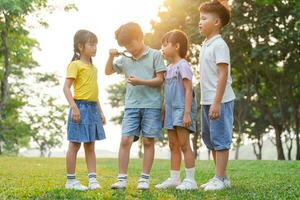 Bild von asiatisch Kinder mit Vergrößerung Glas im Park foto