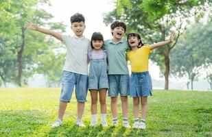 Gruppe von süß asiatisch Kinder haben Spaß im das Park foto