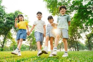 Gruppe von süß asiatisch Kinder haben Spaß im das Park foto