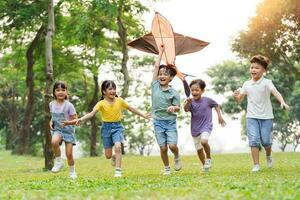 Gruppe Bild von süß asiatisch Kinder spielen im das Park foto