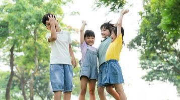 Gruppe von süß asiatisch Kinder haben Spaß im das Park foto