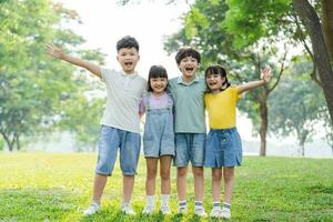 Gruppe von süß asiatisch Kinder haben Spaß im das Park foto