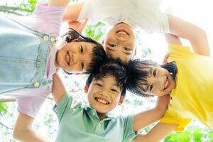 Gruppe von süß asiatisch Kinder haben Spaß im das Park foto