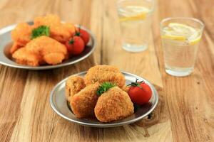 knusprig sofortig Hähnchen Nugget serviert mit frisch Zitrone Wasser foto