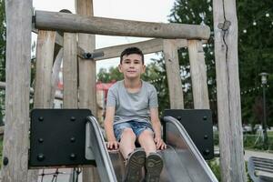 Porträt von ein Junge spielen auf das Spielplatz foto