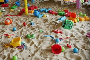 Sand und bunt Spielzeuge im ein Spielplatz drinnen. foto