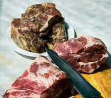frisch Stücke von Schweinefleisch Hals auf ein hölzern Küche Tafel und mariniert Steaks auf ein Platte. Stücke von Schwein Fleisch Nahansicht foto