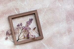 trocken lila Blumen im ein hölzern Rahmen auf ein texturiert Hintergrund. romantisch Gruß Jahrgang Karte. oben Sicht. Kopieren Raum foto