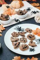 fertig für den Verzehr Halloween behandeln - - Lebkuchen Plätzchen mit Schokolade Glasur auf ein Teller auf das Tisch. Süss Lebensmittel. Vertikale Aussicht foto