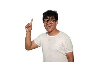 Porträt von emotional asiatisch Schüler haben großartig Idee, finden Inspiration oder Lösung zu Problem. aufgeregt erstaunt Kerl im Brille mit öffnen Mund zeigen Finger oben auf Weiß Hintergrund foto