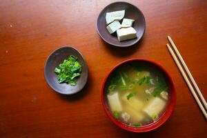 Miso Suppe oder japanisch Miso Suppe im Schüssel auf das Tisch. japanisch Küche im das bilden von Suppe mit dashi Zutaten, Tofu, Meeresfrüchte, Gemüse, und gekrönt mit Miso zu Geschmack foto