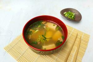 Miso Suppe oder japanisch Miso Suppe im Schüssel auf das Tisch. japanisch Küche im das bilden von Suppe mit dashi Zutaten, Tofu, Meeresfrüchte, Gemüse, und gekrönt mit Miso zu Geschmack foto