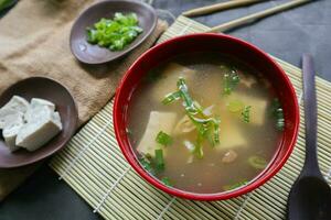 Miso Suppe oder japanisch Miso Suppe im Schüssel auf das Tisch. japanisch Küche im das bilden von Suppe mit dashi Zutaten, Tofu, Meeresfrüchte, Gemüse, und gekrönt mit Miso zu Geschmack foto