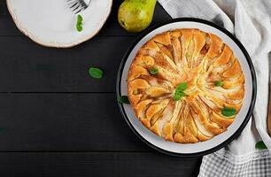 hausgemacht Kuchen mit Birnen und Mandel Mehl auf dunkel Hintergrund. oben Sicht, Overhead foto