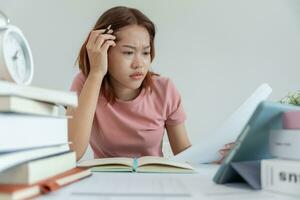 asiatische studentin hat angst wegen prüfungen, frauen bereiten sich auf prüfungen vor und lernen unterricht in der bibliothek. Stress, Verzweiflung, Eile, Missverständnisse beim Lesen, Entmutigung, Erwartung, Wissen foto