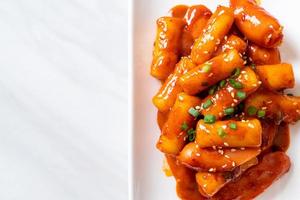 koreanische Reiskuchenstange mit Wurst in scharfer Sauce - tteokbokki foto