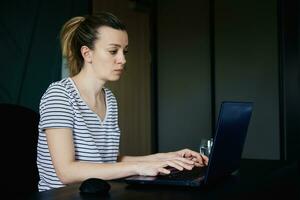 Frau Arbeiten entfernt beim Zuhause Büro mit Laptop foto