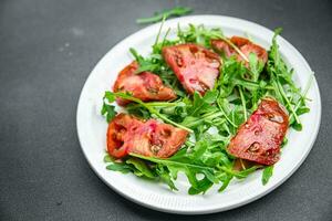 rot Tomate Salat Rucola gesund Mahlzeit Essen Snack auf das Tabelle Kopieren Raum Essen Hintergrund rustikal oben Aussicht foto