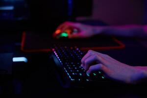 gamer spielen computerspiel, verwenden rgb neonfarbene tastatur foto