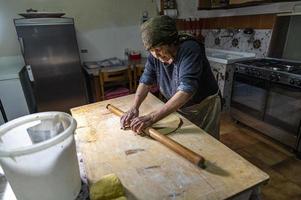 Oma rollt den frisch gekneteten Teig aus foto