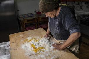 Oma bereitet hausgemachte Pasta zu foto