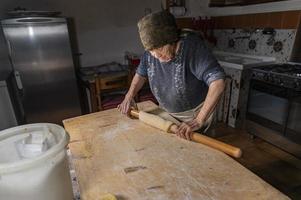 Oma rollt den frisch gekneteten Teig aus foto