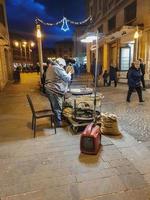 Mann, der im Stadtzentrum gekochte Kastanien an die Öffentlichkeit verkauft foto