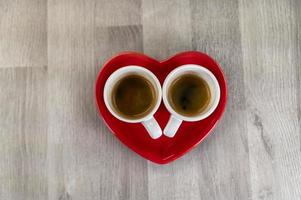 zwei kleine Tassen Kaffee mit Herz-Untertasse