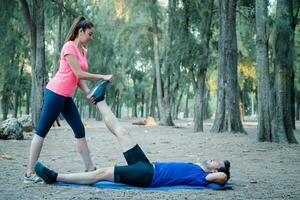 kaukasisch Paar tun Dehnen Übungen im ein Park foto