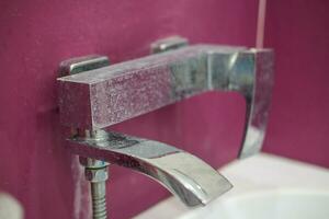 Rührgerät Vor bewirbt sich Reinigung Agent. schmutzig Wasserhahn im das Badezimmer. foto