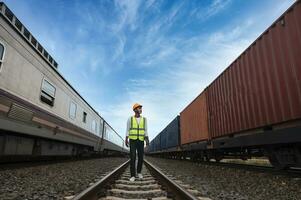 Ingenieur inspiziert Container Zug von Transport Unternehmen Verteilung und Transport von Waren durch Schiene ein Container Zug Vorbeigehen durch ein industriell Bereich foto