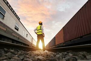 Ingenieur inspiziert Container Zug von Transport Unternehmen Verteilung und Transport von Waren durch Schiene ein Container Zug Vorbeigehen durch ein industriell Bereich foto