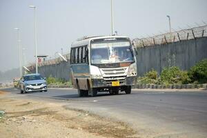 Neu Delhi, Indien - - April 16, 2023 - - Aussicht von Fahrzeuge Vorbeigehen durch das Main Straße in der Nähe von indra Gandhi International Flughafen Delhi beim Zwerg Verknüpfung Straße foto