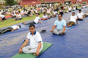 Neu Delhi, Indien, Juni 21, 2023 - - Gruppe Yoga Übung Session zum Menschen beim Yamuna Sport Komplex im Delhi auf International Yoga Tag, groß Gruppe von Erwachsene Teilnahme Yoga Klasse im Kricket Stadion foto