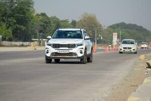 Neu Delhi, Indien - - April 16, 2023 - - Aussicht von Fahrzeuge Vorbeigehen durch das Main Straße in der Nähe von indra Gandhi International Flughafen Delhi beim Zwerg Verknüpfung Straße foto