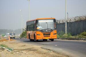 Neu Delhi, Indien - - April 16, 2023 - - Aussicht von Fahrzeuge Vorbeigehen durch das Main Straße in der Nähe von indra Gandhi International Flughafen Delhi beim Zwerg Verknüpfung Straße foto