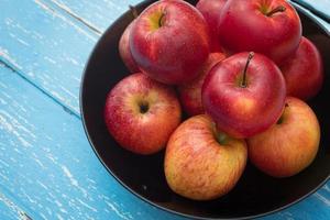 rote Äpfel auf einem Holztischhintergrund foto
