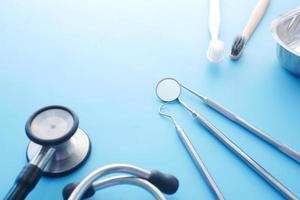 Nahaufnahme von zahnärztlichen Geräten, Stethoskop auf blauem Hintergrund foto