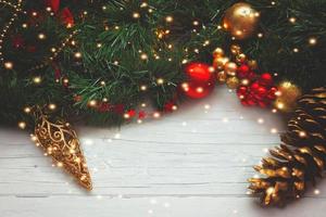 Weihnachtshintergrund - Tannenzapfen und Ornamente auf Holzuntergrund mit Weihnachtsbeleuchtung